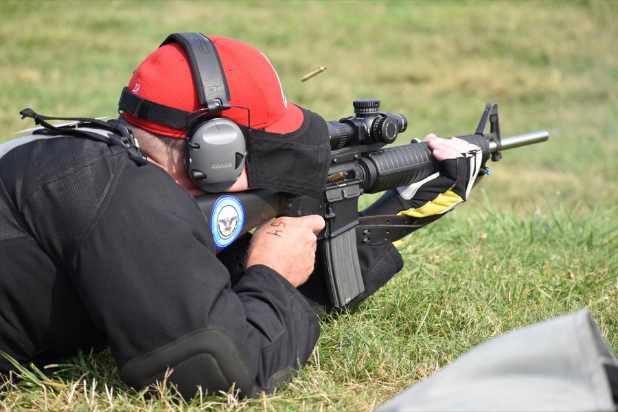Competitor wearing a red cap and Black Coyote Sunshade in the prone position